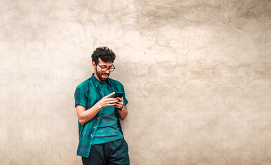 Handsome guy happy with his cell phone, young latin man happy with his cell phone