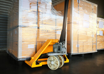 Packaging Boxes Wrapped Plastic Film on Pallets With Hand Pallet Truck. Storage Warehouse. Supply Chain. Storehouse Commerce Shipment. Warehouse Shipping Logistics.	
