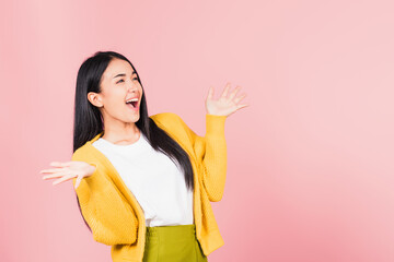 Happy Asian portrait beautiful cute young woman standing winning and surprised excited screaming open mouth raise hands, studio shot isolated pink background, Thai female wow with copy space