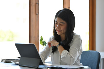 Portrait with confident businesswoman working with her tablet while sitting at the office, Business and financial concept.