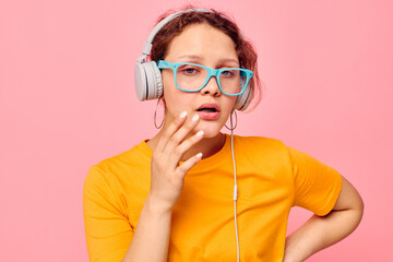 pretty woman yellow t-shirt headphones entertainment music fun pink background unaltered