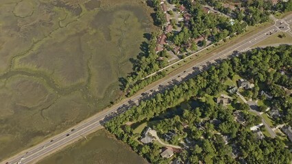 Savannah Georgia Aerial v49 vertical birds eye view overlooking at traffic crossing on highway away from the neighborhood at whitemarsh island surrounded by beautiful natural marshland - October 2020