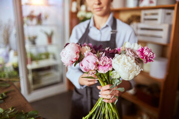 Florist arranging flowers for pink tender bouquet