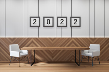 Modern guest room interior with two seats on wooden floor and 2022 posters