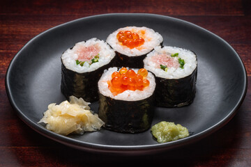 Japanese style setting of sushi rolls with caviar and chopped fresh fish on plate, Asian food, traditional Japanese food
