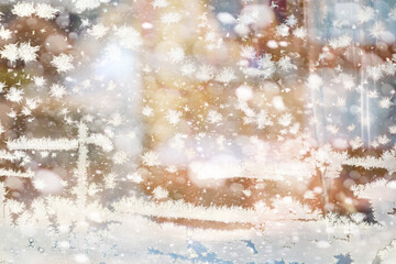 Winter landscape through a frozen window. Blurred snow background. Trees and plants covered with snow.