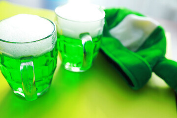 Saint Patrick's Day holiday. National Irish holiday. Green beer. Hand with a mug of emerald beer in a bar.