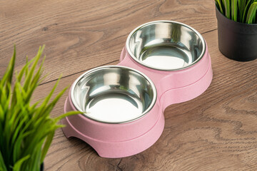 bowl for cat food on a wooden background. double bowl for water and cat food