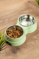 bowl for cat food on a wooden background. double bowl for water and cat food