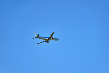 Aircraft of the company KLM after takeoff. Single flying object in front of blue sky. Up view.