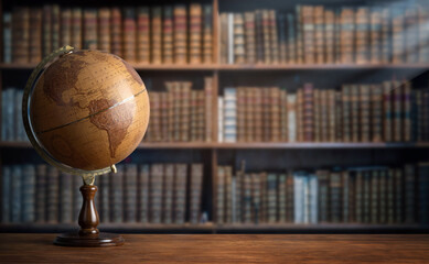 Old geographic globe in the cabinet against the background of bookselfs.Science, education, travel,...