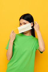 Portrait Asian beautiful young woman with a medical mask in hand protection isolated background unaltered