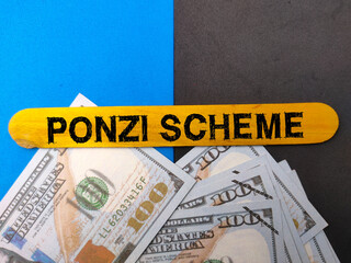 Top view banknotes and colored ice cream stick with text PONZI SCHEME on colored background.