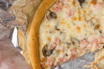 freshly baked pizza in a cardboard box and in foil