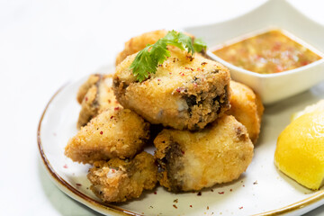 Crispy fried fish sea bass fillets served on plate.