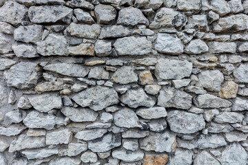 Fragment of an old gray stone wall old gray masonry