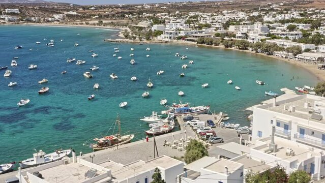 Aliki Paros Greece Aerial v3 birds eye view capturing seaside and hillside fishermen village with fishing boats moored on beautiful clear blue aegean sea - September 2021