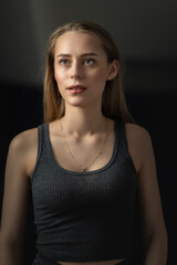 Naklejka premium Portrait of a young beautiful blonde girl in a sports uniform in the gym.
