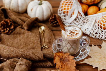 Cup of Pumpkin Spice Latte and Fall Decor from fresh  pumpkins. Traditional Coffee Drink for Autumn Holidays, cozy, hygge, comfortable