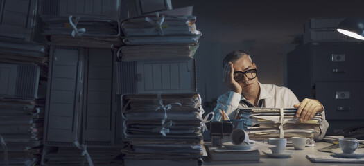 Exhausted businessman working overtime in the office