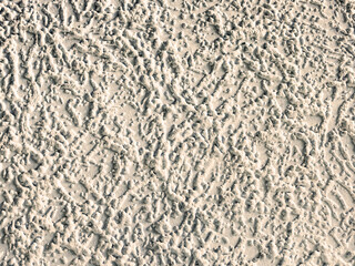 The texture of the plaster on the wall, the background with a relief pattern of brown sepia