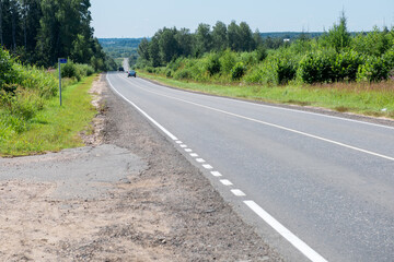 Fototapeta na wymiar Highway goes along the wooded countryside on a summer sunny day