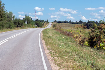 Fototapeta na wymiar Highway goes along the wooded countryside on a summer sunny day