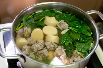 Clear soup with egg tofu, minced pork and ivy gourd in a pot; Thai cuisine.