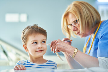 Pediatrician doctor examining little kids in clinic ears check