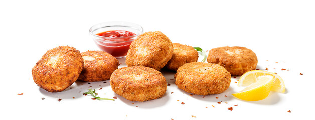 Chicken patties or fish cakes fried in breadcrumbs with ketchup and lemon slices. isolated on white...