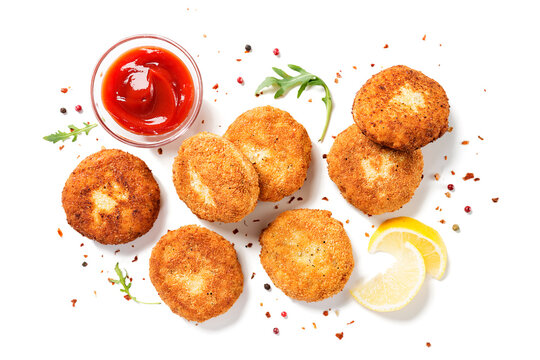 Chicken patties or fish cakes fried in breadcrumbs with ketchup and lemon slices. isolated on white background, top view