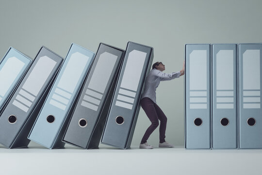 Businesswoman holding falling ring binders