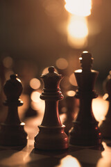 Wooden chess pieces on the chessboard and dim light