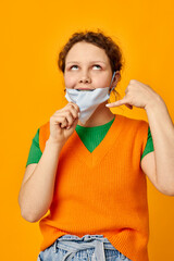 portrait of a young woman in a yellow t-shirt medical mask protection cropped view unaltered