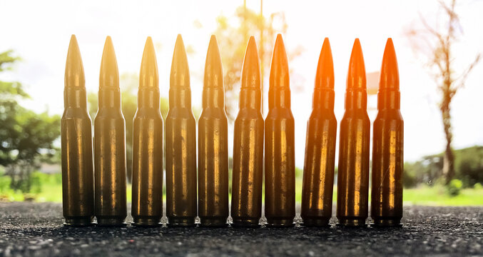 Closeup old rifle bullets on cement floor with blurred background. Soft and selective focus. vintage bullets collections concept.