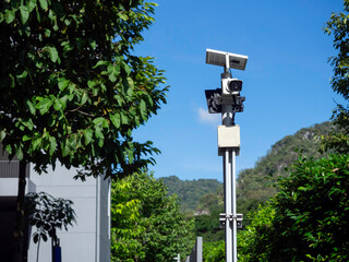 Modern white CCTV camera electronic security system with solar light panel and street light on the...