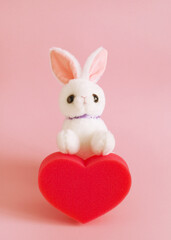 cute bunny toy and red sponge  heart  pink vertical greeting card happy valentines day