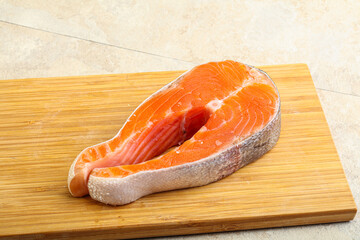 Raw salmon steak over board