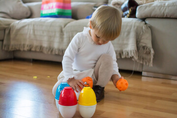 Young Baby Playing At Home.
Stock Photo Of Adorable Little Baby Sitting In The Floor Playing With Toys.