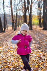 Happy little girl in the park. Autumn season.