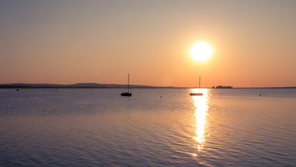 Obraz premium Two boats lonely on the lake at sunset