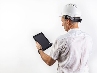 Male engineer in a white hard helmet. Middle-aged man in a white shirt with a tablet computer. Back view. Isolated portrait on a white background. Male stock photo. Copy space
