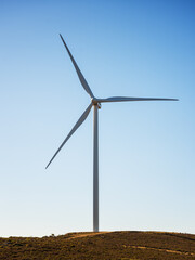 Fototapeta na wymiar Wind turbines on a beautiful blue sky in a mountain wind farm in Sardinia. Renewable energy concept, green energy generation. Energy industry.