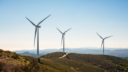 Wind turbines on a beautiful blue sky in a mountain wind farm in Sardinia. Renewable energy...