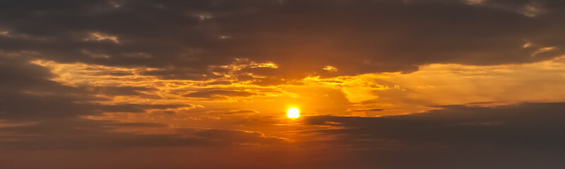 Evening landscape with the setting sun in the clouds in summer