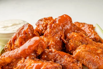 Foto op Canvas Buffalo wings traditional american recipe close up. Fried bbq wings covered with sauce. © Alexandr Milodan