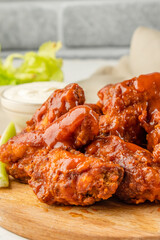 Buffalo chicken wings with cayenne pepper sauce served hot with celery sticks and carrot sticks with blue cheese dressing for dipping and beer
