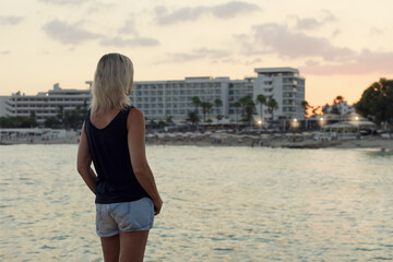 Mature woman enjoying sunset on the beach. Woman freedom feeling at sunset,thinking. Summer vacation on Cyprus.