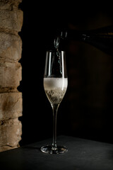 Elegant crystal champagne flute filled with sparkling champagne isolated on black background