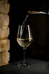 Dark bottle up to half elegant crystal champagne flute with sparkling champagne
